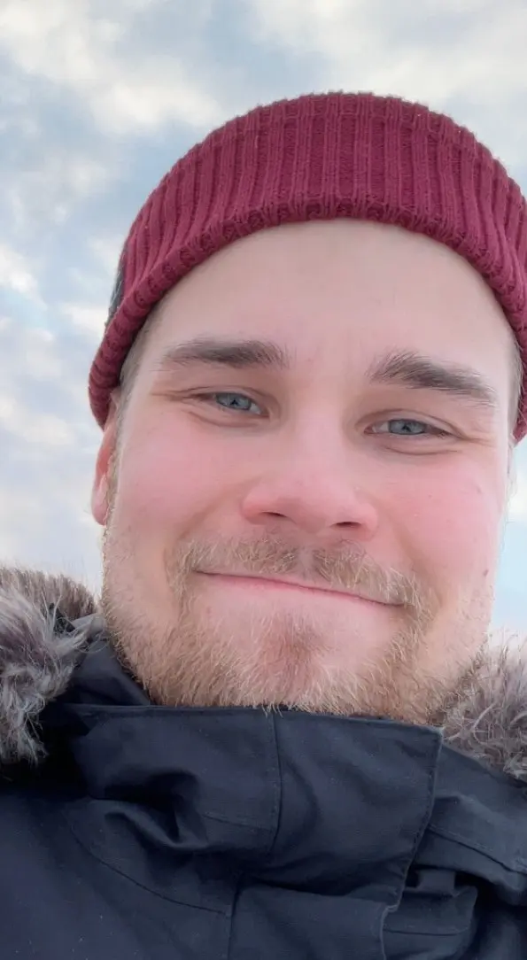 Selfie of the entrepreneur. Winter clothes on, red beanie and smile on the face.